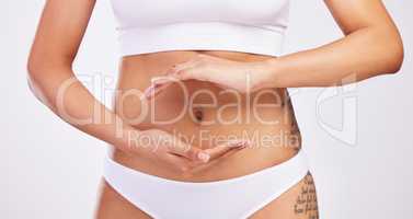 Loving yourself start with how you treat yourself. Shot of an unrecognisable woman framing her navel with her hands.