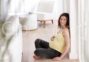 Im in love with a child I havent yet met. Shot of a young pregnant woman sitting on her living room floor.