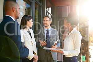 If we work together, well make a success of this. Shot of a diverse group of businesspeople having a meeting on a balcony in bright sunlight.