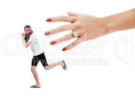 Fear of commitment. A young man trying to run away from a giant hand wearing a wedding ring.