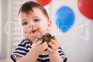 Its his birthday... Hes allowed to indulge. Shot of a baby boy eating some cake on his birthday.