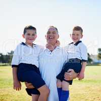 Their love for soccer is a family affair. Portrait of a proud father holding his two sons after a soccer game.