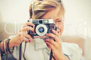 She chose to remain focused. Closeup shot of a beautiful young woman taking a photograph.