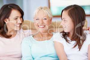 A proud grandmother. A happy grandmother sitting with her daughter and granddaughter smiling widely.