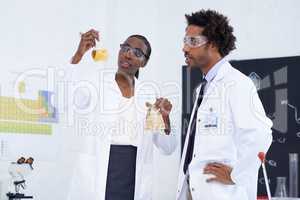 Making science breakthroughs. Shot of two scientists conducting an experiment in their lab.