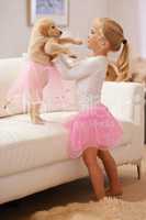 Now you can be a princess too. A little girl dressing her puppy in a tutu.