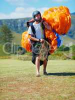 Ready for action. Shot of a man carrying his paragliding equipment.