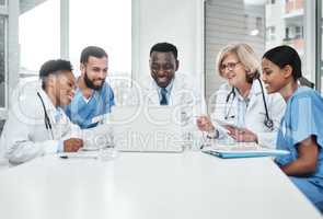 Its all about exceptional healthcare. Shot of a group of medical practitioners using a laptop during a meeting in a hospital boardroom.