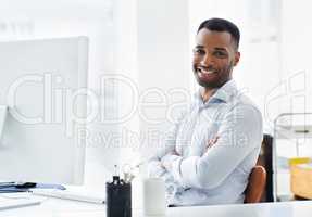 Hes confident in his career. A handsome young african american businessman working at his desk.