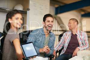 They like to keep things light hearted around the office. Shot of team of colleagues having an informal meeting with a digital tablet.