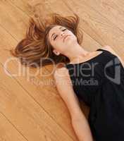 Alluring beauty. Shot of a n attractive young woman lying on the floor with her eyes closed.