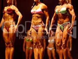 Flexing for the judges. Female body building contestants flexing their muscles for the judges.