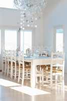 White interior with dining table and chairs and chandelier. Contemporary white interior with dining table and chairs and chandelier.