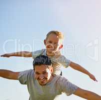 Letting his sons imagination soar. Shot of a father giving his son a piggyback on a sunny day.