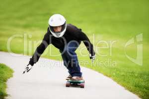 Focused on going fast. Shot of a skateboarder making his way down a lane on his board.