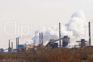 Polluting the air one cloud at a time. Shot of air pollution over an industrial area.