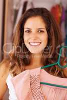 Woman happy with the selected dress. Closeup of an attractive woman with an outfit from the wardrobe.