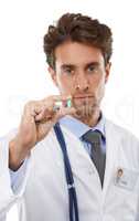 This is going to help you. Studio portrait of a serious-looking young doctor holding a pill up to the camera.