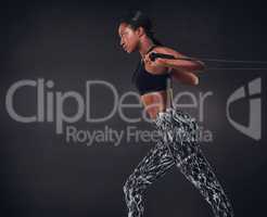 Upper body strength at its best. Studio shot of a beautiful young woman working out against a black background.