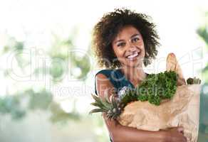 Bag of health. Young girl smiling while holding her groceries - isolated.