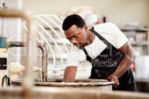 Hes a jack of all trades in his bakery. Cropped shot of a young man working in a bakery.