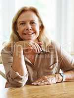 Life has been good to me. Portrait of a senior woman smiling at the camera while sitting indoors.