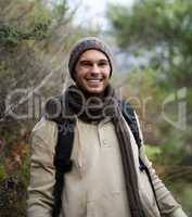 He loves getting in touch with nature. Portrait of a handsome young man hiking in the mountains.