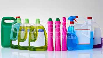 Domestic detergents. Studio shot of various bottles of detergents against a grey background.