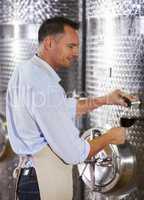 His passion comes through in the quality of his wines. A mature wine maker testing a batch of his red wine.