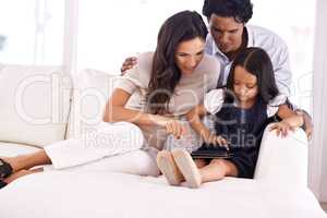 Sometimes the kids know best. Full length shot of an affectionate young family sharing a digital tablet.