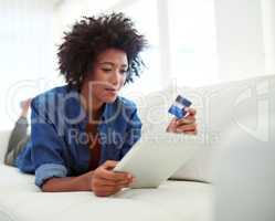 Comfortable consumerism. Shot of an attractive young woman shopping online from the comfort of home.