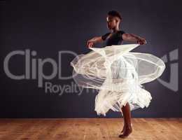 Freedom of expression. Young female contemporary dancer using a soft white white skirt for dramatic effect.