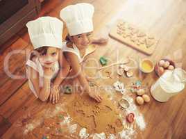 The cute factor in the kitchen just went up. Shot of two little girls baking in the kitchen.
