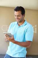 Downloading a new app. Shot of a handsome man using a digital tablet indoors.