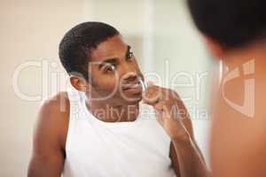 A brush a day keeps the decay away. A young man brushing his teeth.