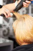 Perfecting every strand of hair. A blonde woman getting her hair blow dried at the hairdresser.