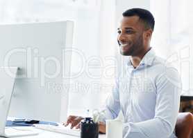Enjoying his work. A handsome young african american businessman working at his desk.