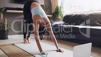 This is great for my back. Shot of a young woman practising a yoga routine at home.