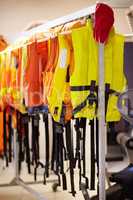 Ready when needed. Cropped shot of life jackets hanging on a rail inside a lifeguard station.