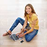 Taking some time to browse and relax. Portrait of a young woman sitting on the floor with her cellphone and laptop.