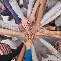 All for one and one for all. Cropped shot of a business team standing in a circle with their hands stacked.