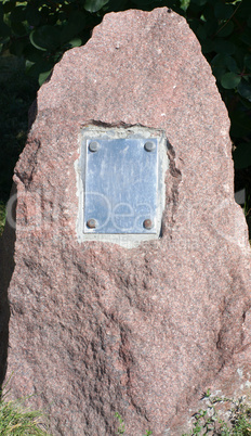 metal plate on granite stone in park at dry sunny summer day