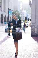 A quick break be. Shot of a businesswoman multi-tasking while on her way to work.