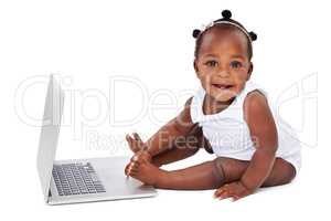 The cure for boredom is curiousity. Studio shot of an adorable baby girl using a laptop isolated on white.