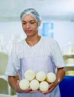 These are going off to storage. Cropped shot of a woman working in a cheese factory.