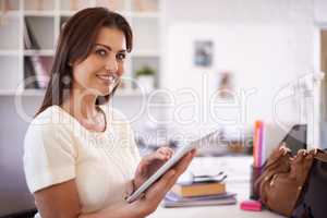 Using all the tools of the trade. A beautiful young businesswoman holding a tablet.