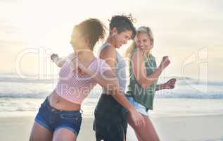 We only have fun on days ending with y. Shot of three friends spending the day at the beach.