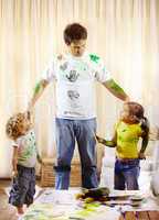 You two have some explaining to do. Shot of a paint covered father scolding his children for making a mess.
