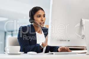 Communicating in an effective manner. Shot of a young businesswoman working on a computer in a call centre.