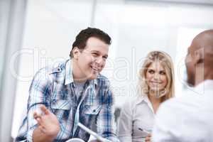 He is confident in his team members abilities. A group of professionals having a work discussion.